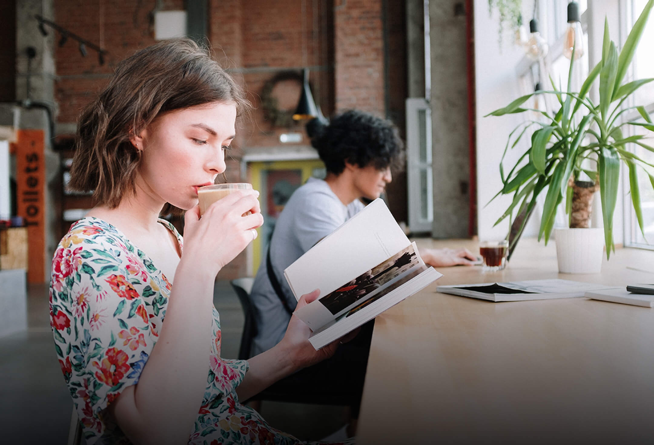 店内で、リラックスしながらコーヒーを飲み、本を読むイメージ写真